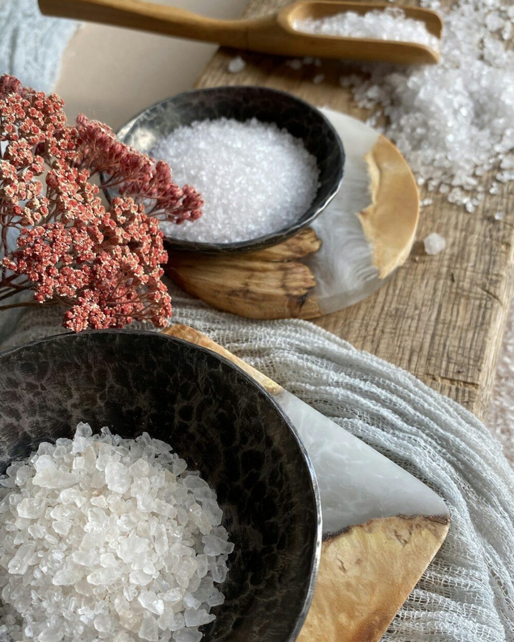 Bowls of coarse salt beside folded linen