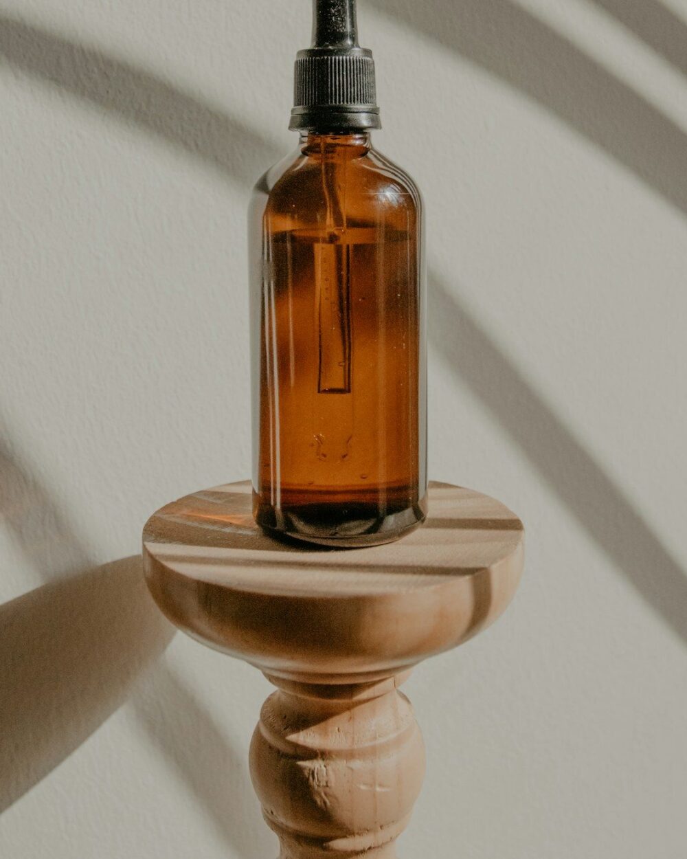 Amber glass bottle against a warm wall