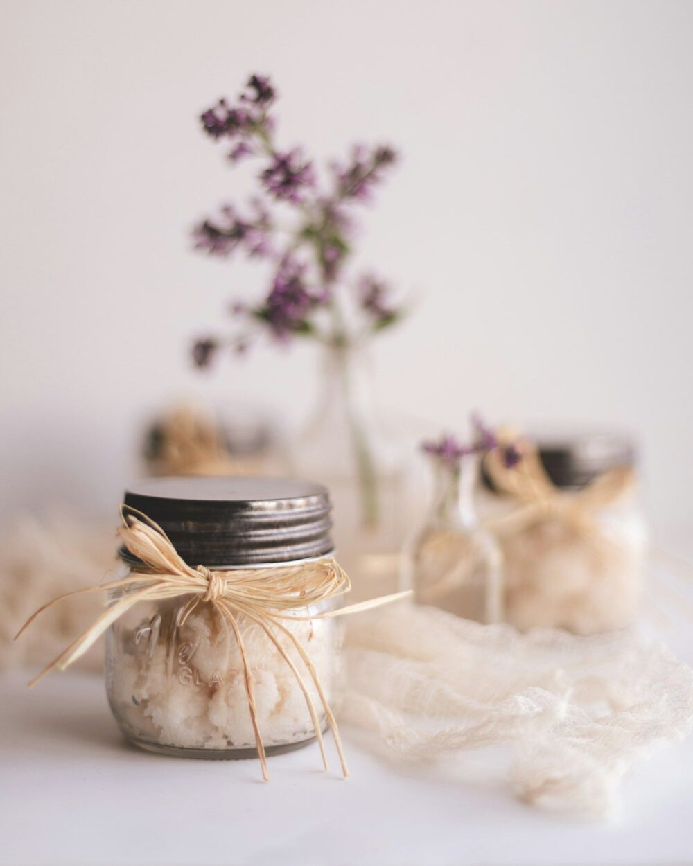 Scrub jars tied with twine beside dried flowers