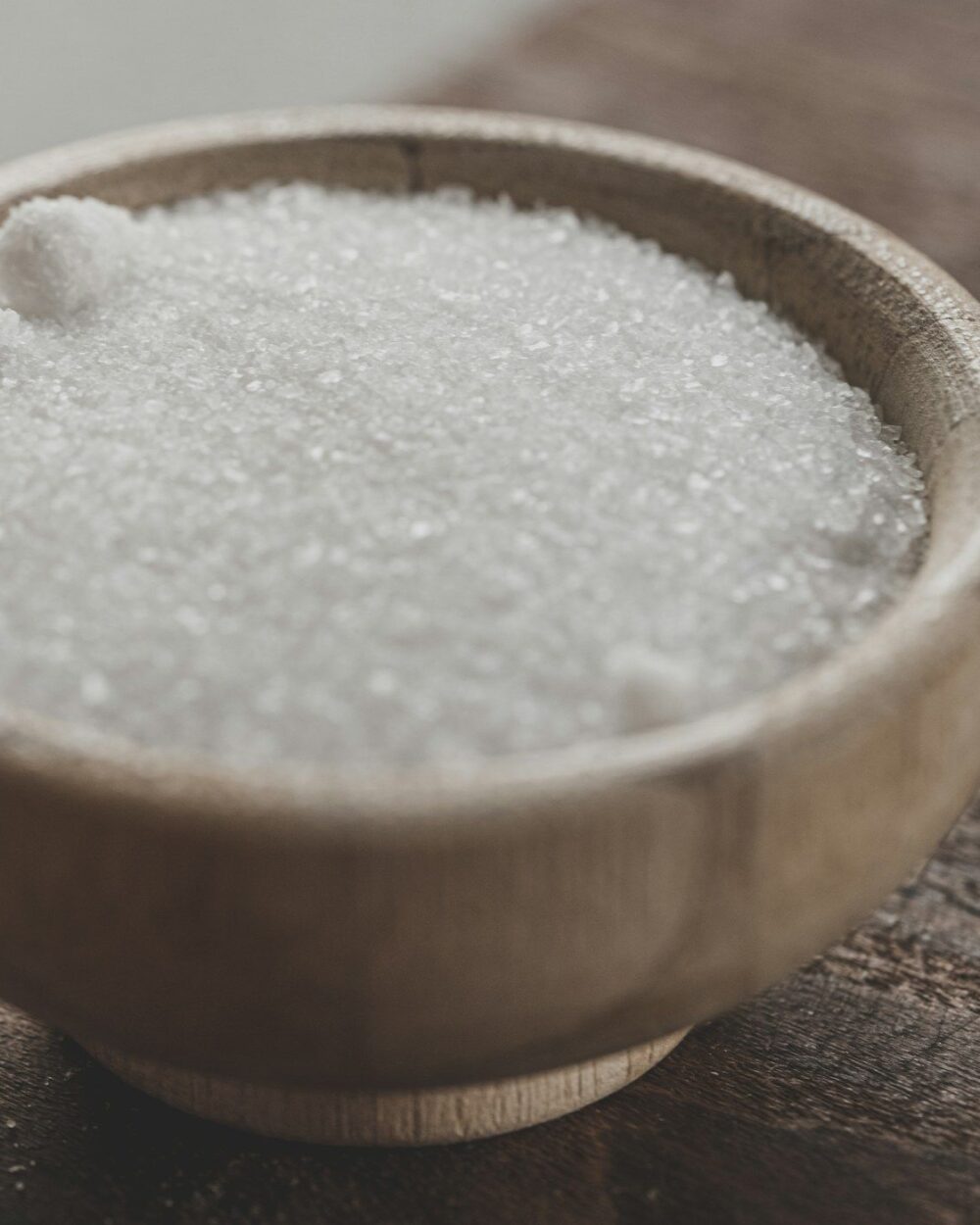 Pale sugar scrub heaped in a wooden bowl