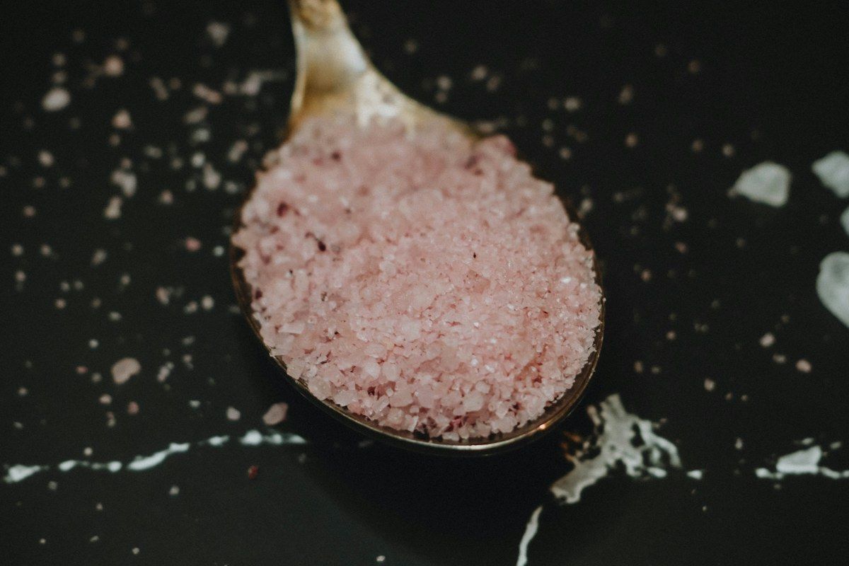 Pink salt on a dark spoon